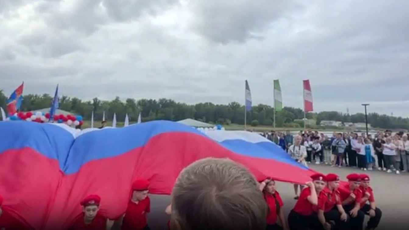 На набережной в Красноярске провели школьную линейку с огромным триколором